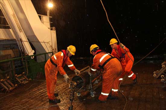 “海洋六號”科考隊員太平洋雨夜中作業收樣品